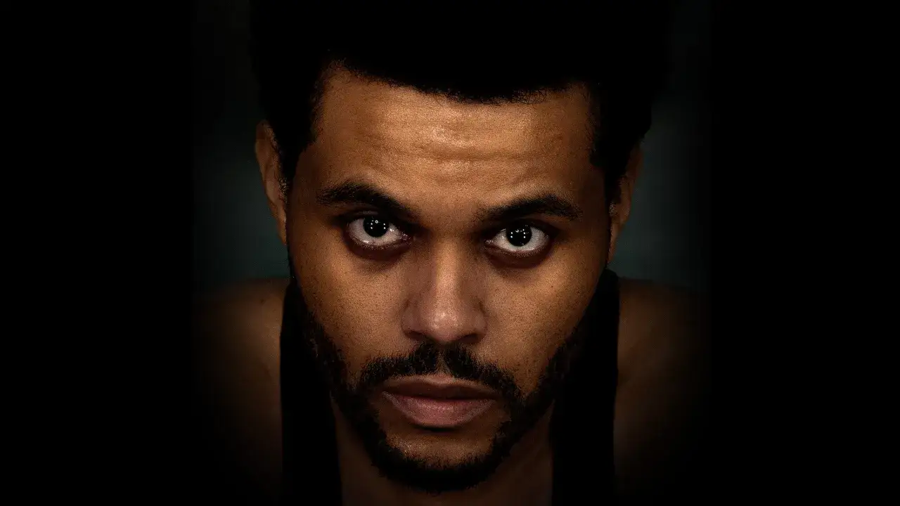Nahaufnahme von The Weeknd, dessen Blick intensiv ist. Seine Herkunft ist ein Mysterium, das seine Musik umgibt.