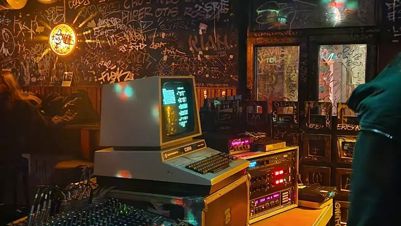 Ein Commodore CBM-Computer, wie ihn Robert Henke nutzt, steht auf einem Mischpult. Die Wand ist mit Graffiti bedeckt.