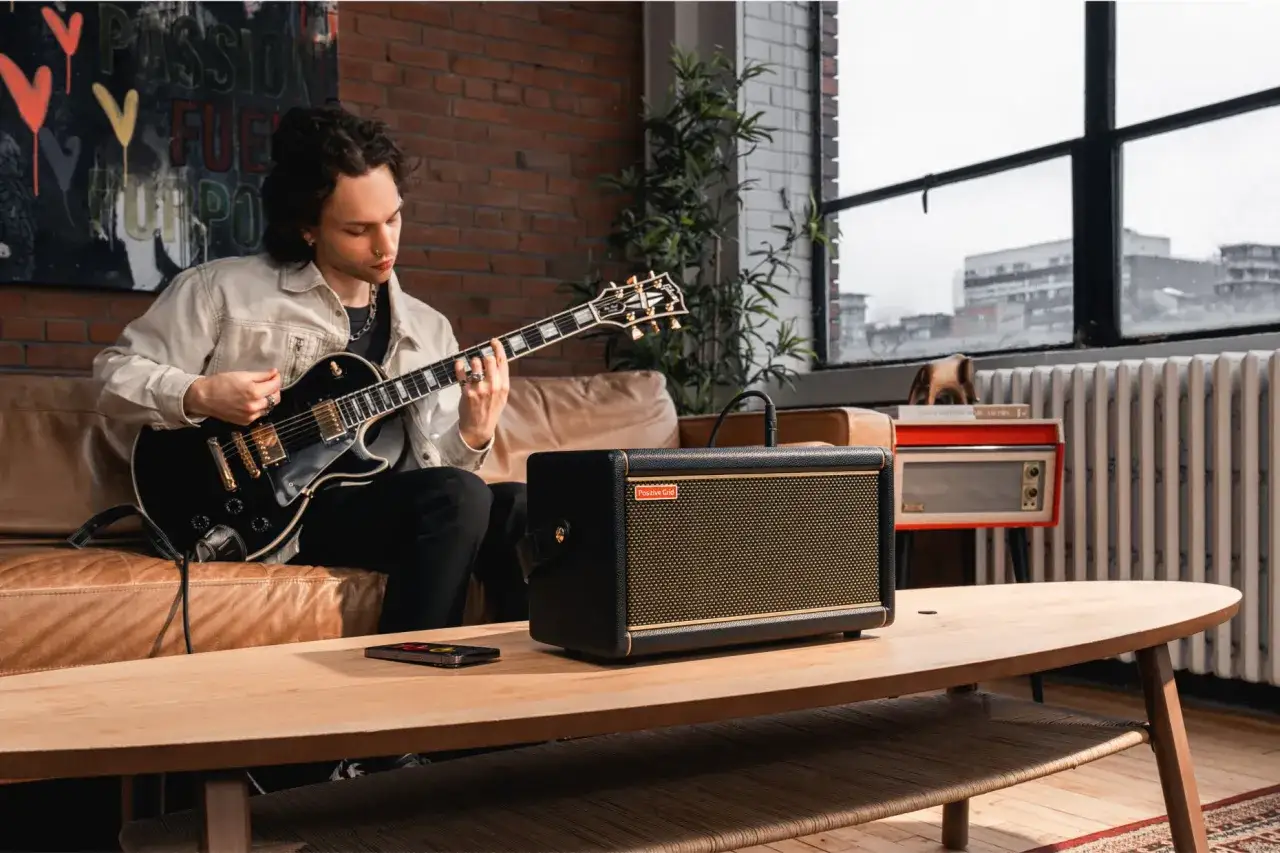 Mann spielt Gitarre, daneben ein Verst&auml;rker mit dem Logo 