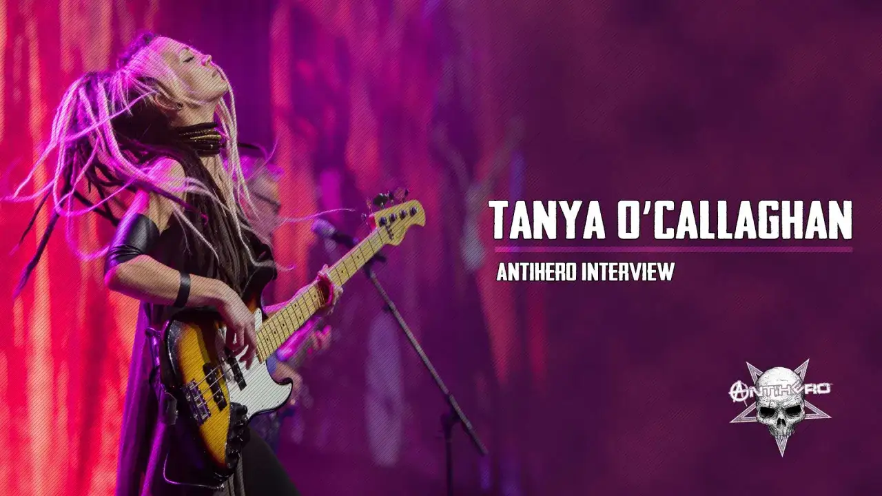 Tanya O'Callaghan, eine Bassistin mit Dreadlocks, spielt auf der Bühne. Der Schriftzug
