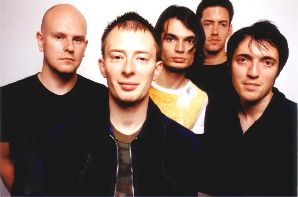 Fünf Mitglieder von Radiohead posieren für ein Foto. Thom Yorke steht im Vordergrund, flankiert von seinen Bandkollegen.